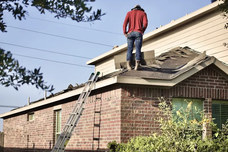 Professional roofer working on a residential roof in Elmendorf